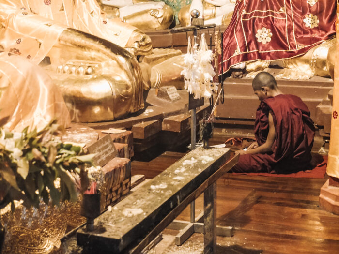 Buddhist monk praying in temple in Myanmar Portfolio YourTravelReporter.nl