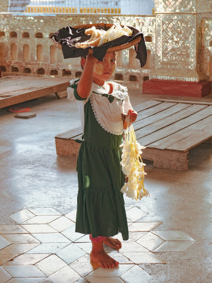 Klein meisje met bloemen in tempel in Myanmar Portfolio YourTravelReporter.nl